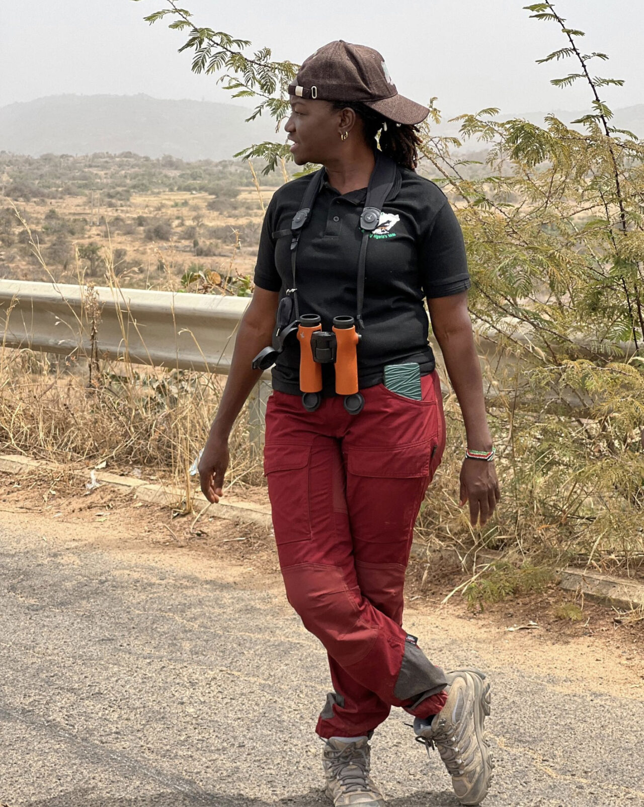 Woman stands with binoculars.