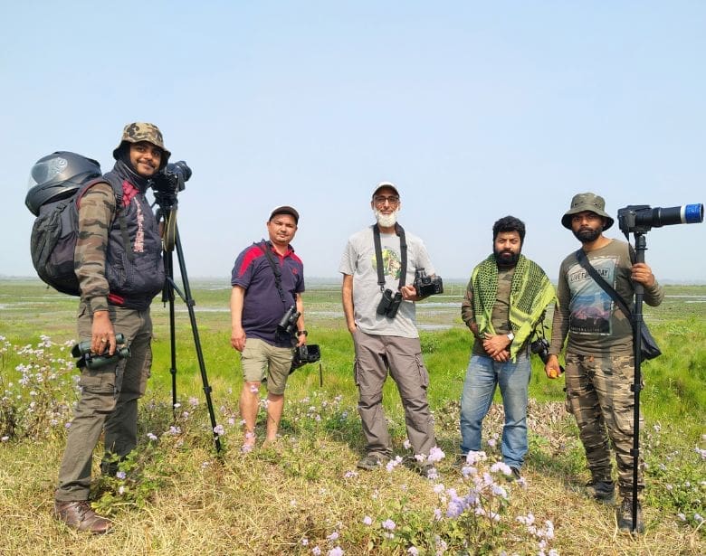 A group of people birdwatching.