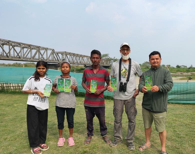A group of people smiling and holding pamphlets.