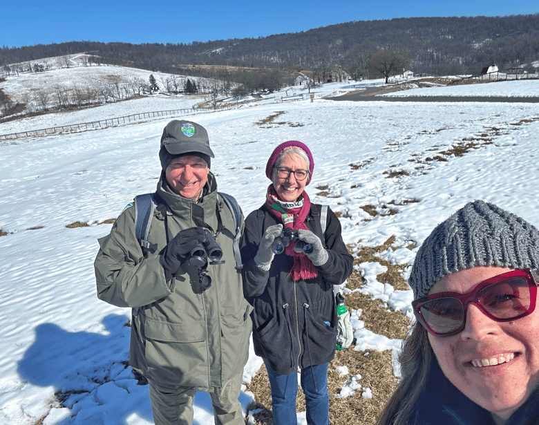 A group of people smiling with binoculars.