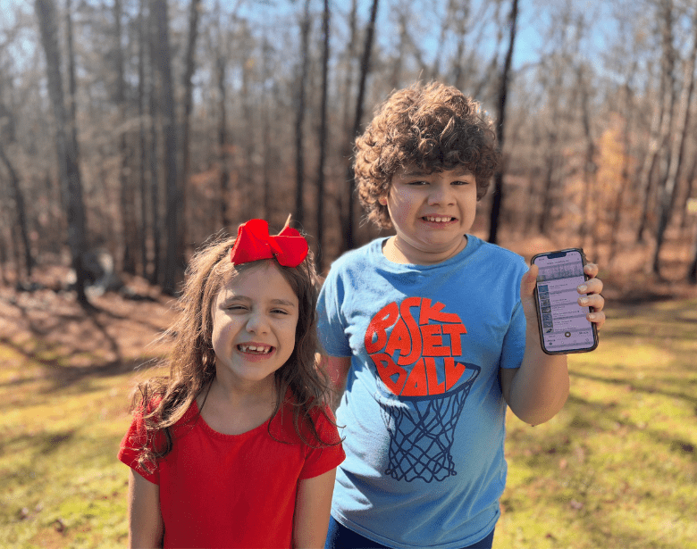 Two smiling children using the Merlin Bird ID app.