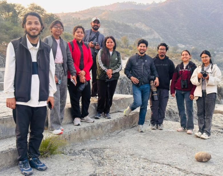 Group of people with binoculars smiling.