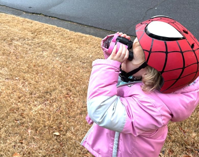 A child with binoculars, birdwatching.