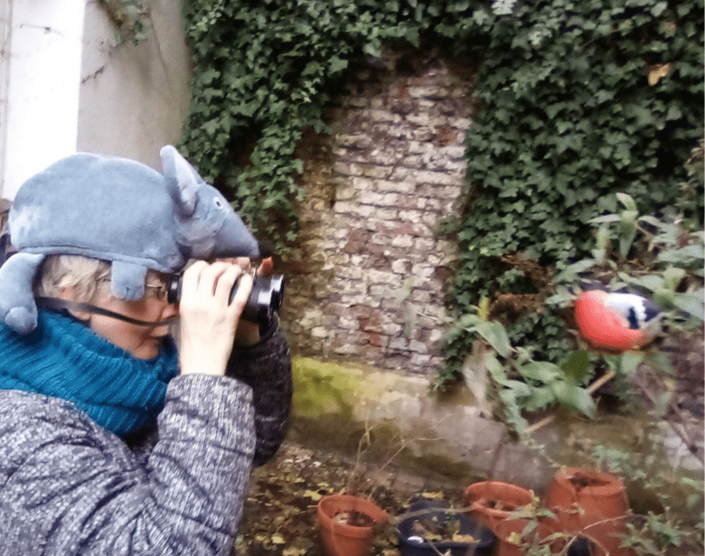 A person birdwatching with binoculars.
