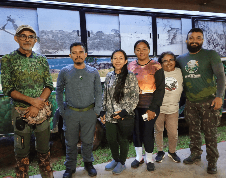 A smiling group of people standing in front of a painted bus.