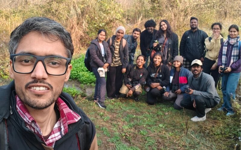 Group of smiling people with binoculars.