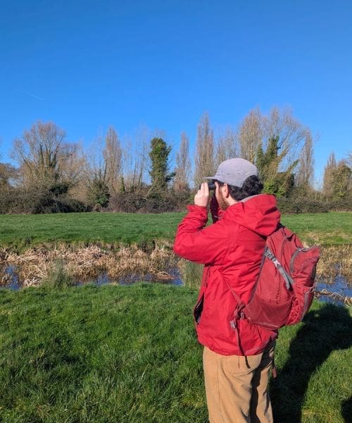 A person birdwatching with binoculars.