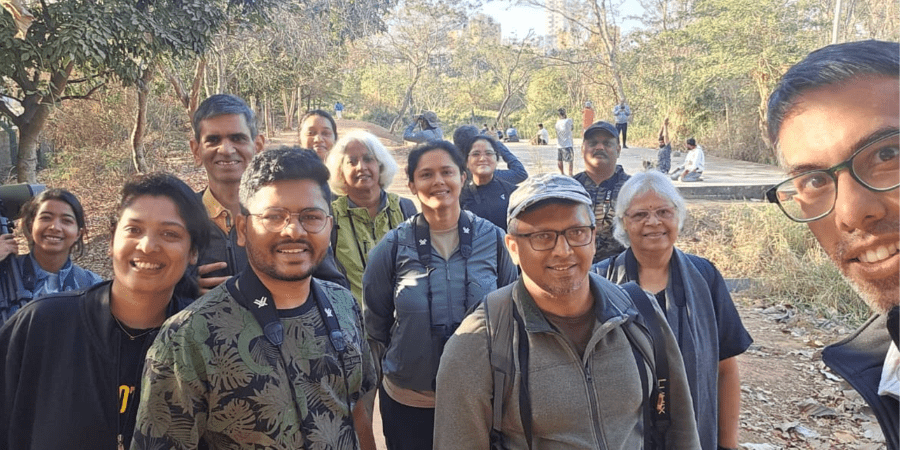 Group of smiling people with binoculars.