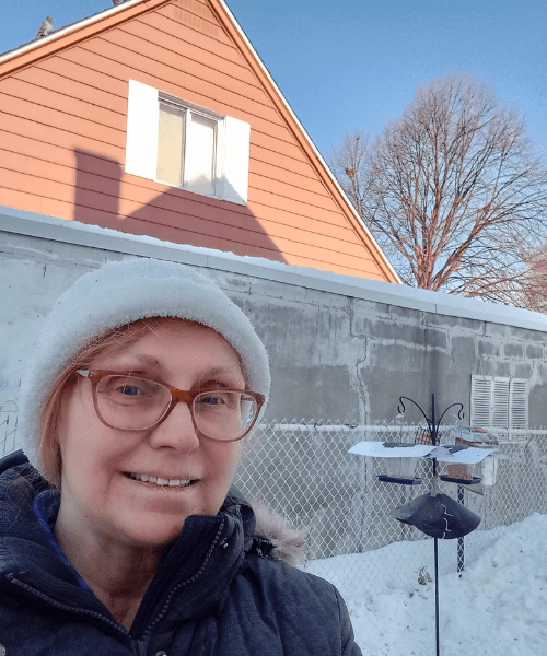 A person smiling in an outdoor snowy area.