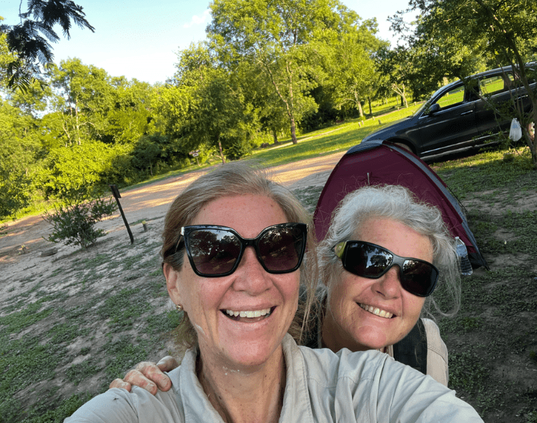 Two smiling people in an outdoor sunny area.