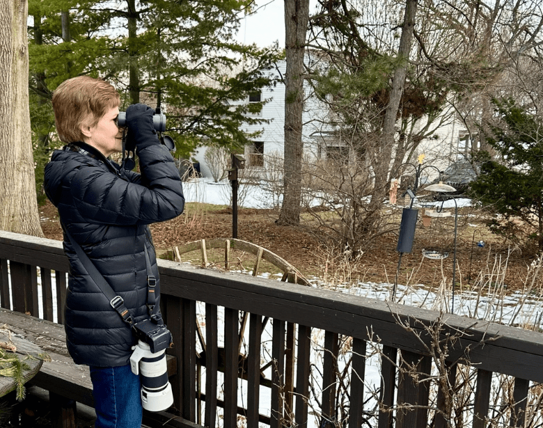 A person birdwatching with binoculars.