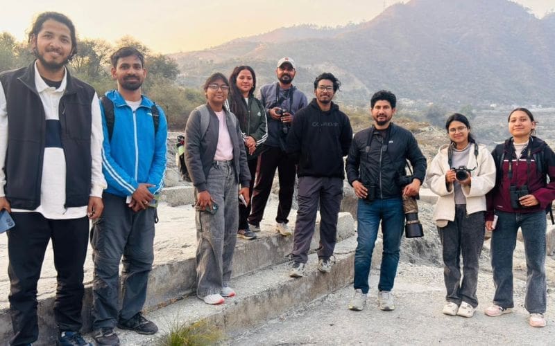 Group of smiling people with binoculars.