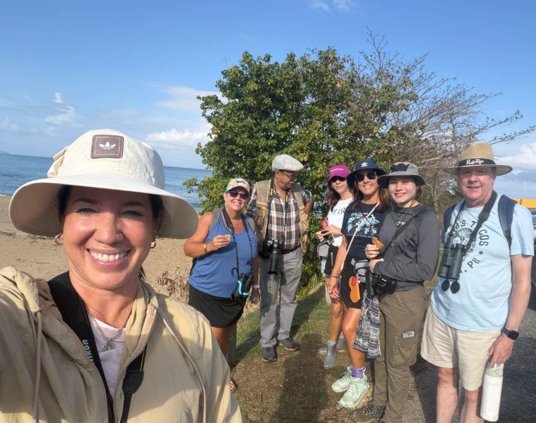Group of smiling people with binoculars.