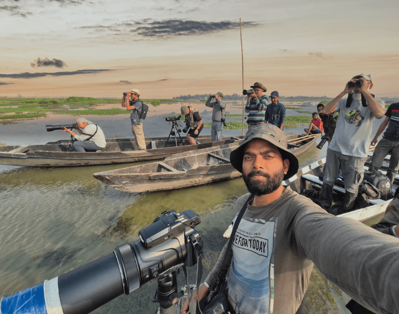 A group of people birdwatching with birdwatching equipment on boats.