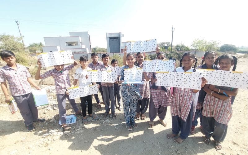 A group of children smiling and holding posters of birds.