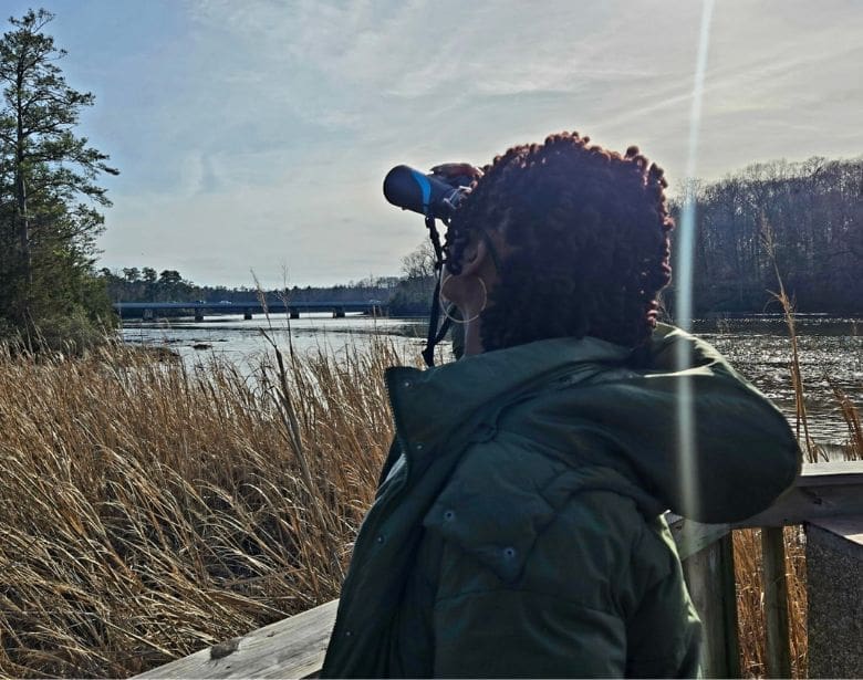 A person birdwatching with binoculars.