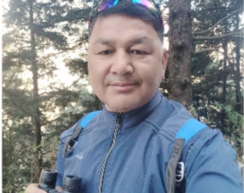 A person smiling while holding binoculars.