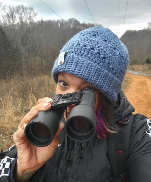A person birdwatching with binoculars.