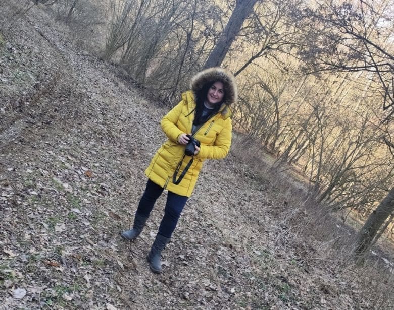 A person smiling while holding binoculars.