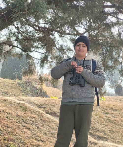 A person smiling with binoculars.