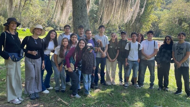 Group of smiling people with binoculars.
