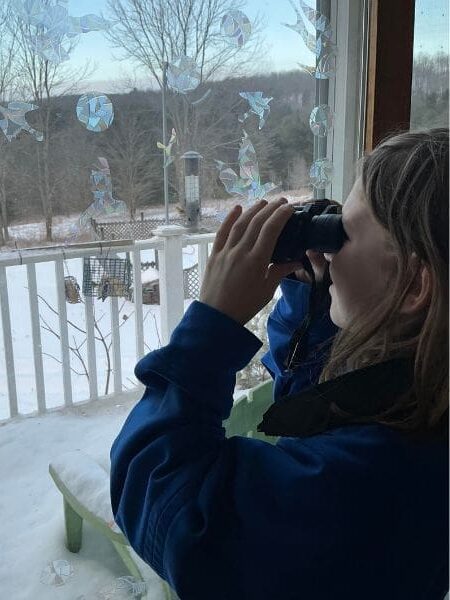 A child using binoculars to birdwatch.